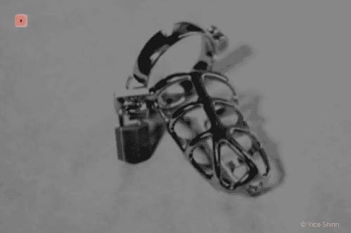 Fotografía en blanco y negro de una jaula de castidad metálica de anillos curvos con candado