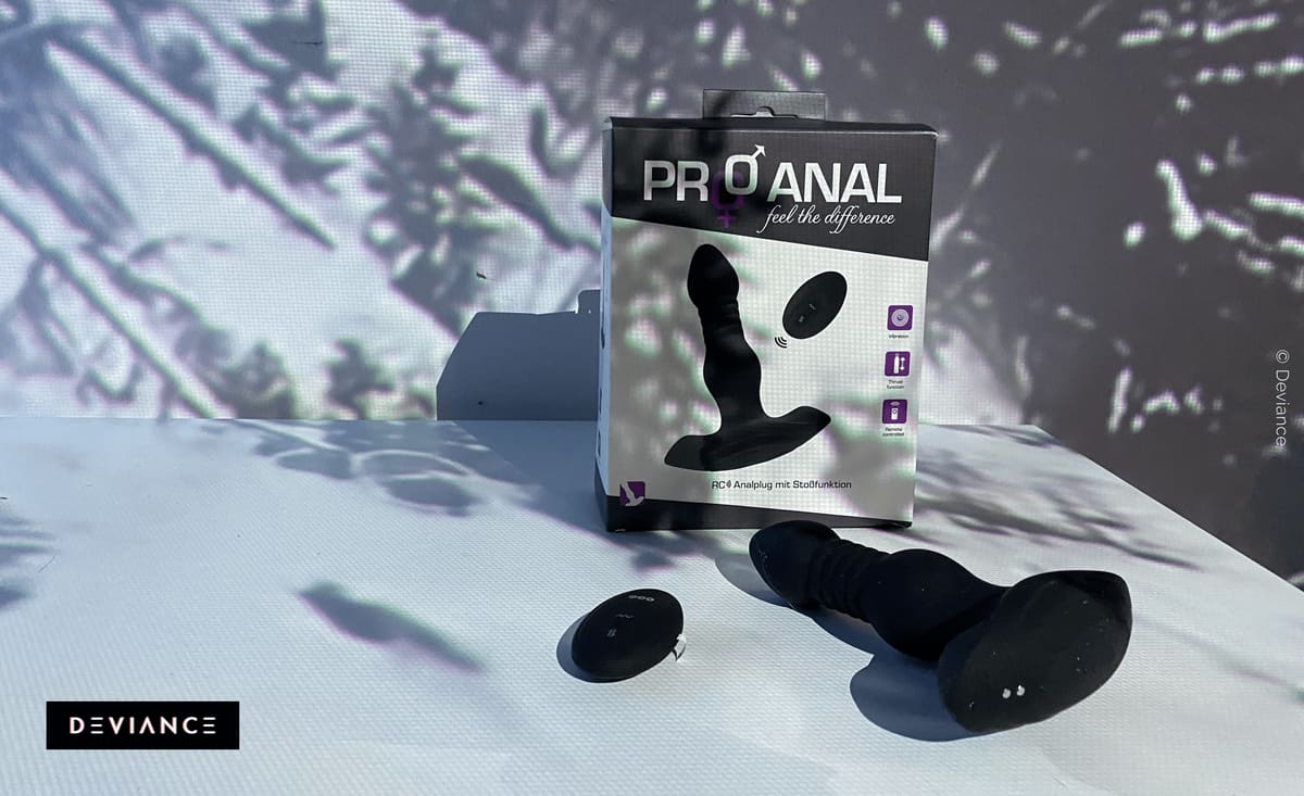 Envase del plug anal por control remoto «Pro Anal» junto al plug negro desempaquetado y su mando sobre una superficie clara