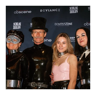 Cuatro personas posando ante el photocall de Obscene 2025, tres de ellas con conjuntos de látex, máscara y chistera