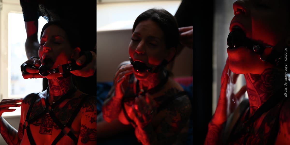 Tres imágenes bajo luz roja: una mordaza de bola negra siendo colocada a una persona tatuada, luego puesta, y en la tercera saliva cayendo por la comisura de los labios