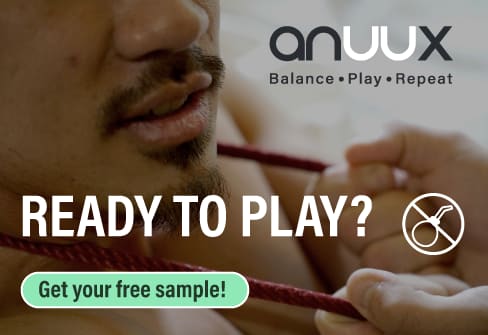 anuux advertising banner with the slogan “Balance · Play · Repeat”, the question “Ready to play?” and the call to action “Get your free sample!”, behind it a person holding a red cord between their teeth