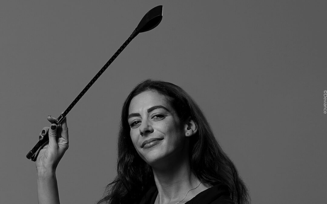 Gründerin Marina von Deviance mit Gerte in der Hand – ein Bild über Macht, Haltung und BDSM Liebe.