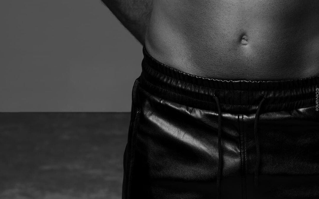 Der Schritt eines Mannes in lederner Hose, symbolisches Bild für Small Penis Humiliation (SPH) und feminisierende Elemente im BDSM.